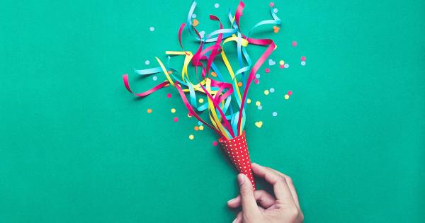 hand holding a noise maker and confetti